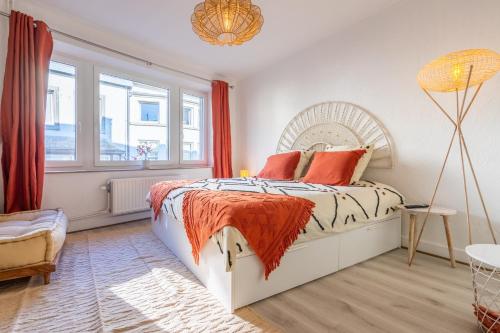 a bedroom with a bed with orange pillows at Eglise 26 Aparthotels in La-Roche-en-Ardenne