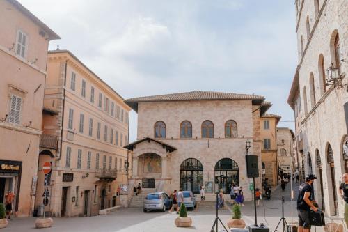 a man standing on a street in front of a building at Casa Dalia, colazione inclusa e vista panoramica in Assisi