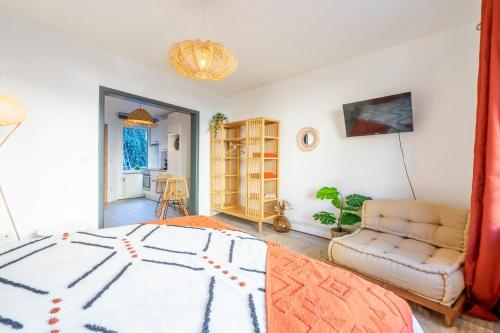 um quarto com uma cama, um sofá e uma cadeira em Eglise 26 Aparthotels em La-Roche-en-Ardenne