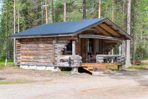 a log cabin with a solar roof in the woods at Holiday Village Himmerki in Posio