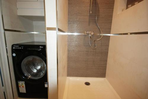 a shower in a bathroom with a washing machine at Studio - Confort - Climatisé - Le Refuge de Charles - Jardin in Bures-sur-Yvette