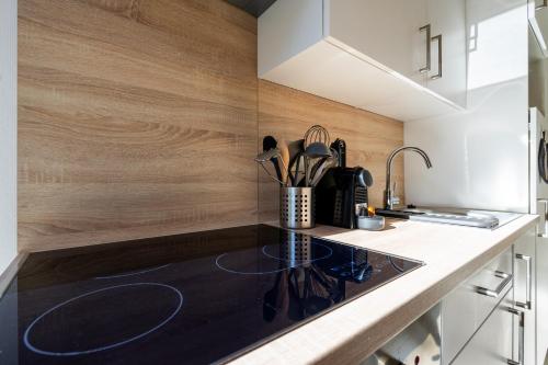 a kitchen with a black counter top and wooden walls at Eglise 26 Aparthotels in La-Roche-en-Ardenne
