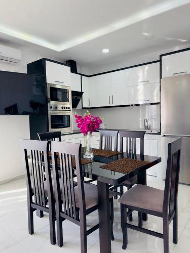 a kitchen with a table and chairs and a kitchen with white cabinets at Villa Merkuri in Himare