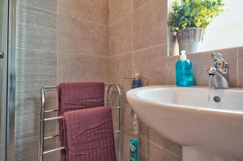 a bathroom with a white sink and a mirror at Fliss's House in Leicester