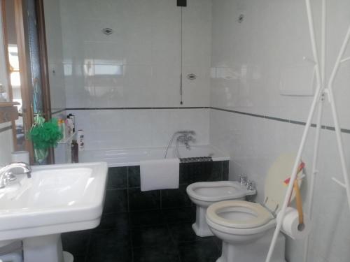 a white bathroom with a toilet and a sink at La stanza dello Scirocco in Celle Ligure