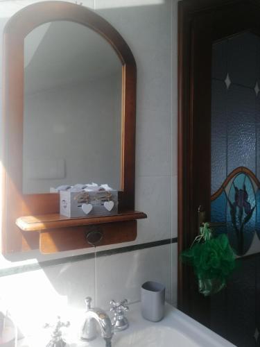a bathroom with a sink with a mirror and a sink at La stanza dello Scirocco in Celle Ligure
