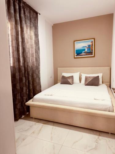 a bedroom with a bed and a curtain at Villa Merkuri in Himare