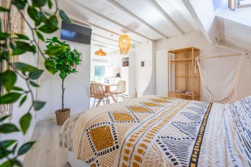 um quarto com uma cama e uma mesa com uma planta em Eglise 26 Aparthotels em La-Roche-en-Ardenne