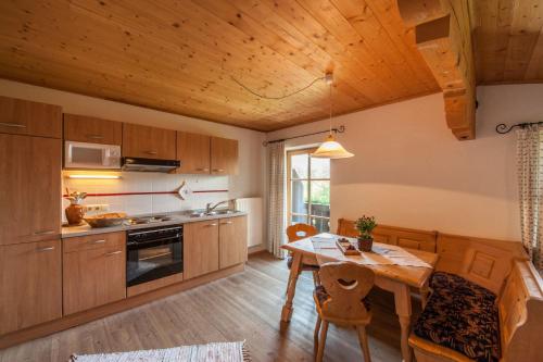 a kitchen with wooden cabinets and a wooden table with a dining room at Zugspitzhotel Diana Thörle in Ehrwald