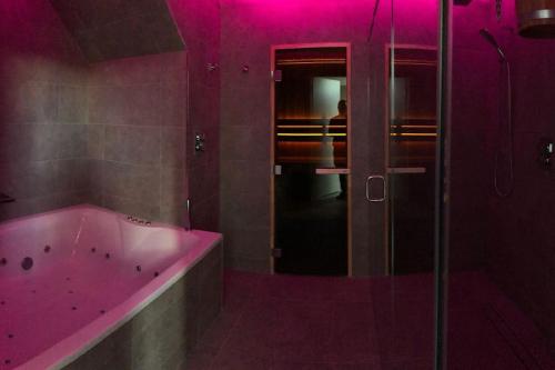 a pink bathroom with a tub and a shower at Slate House in Ballybunion
