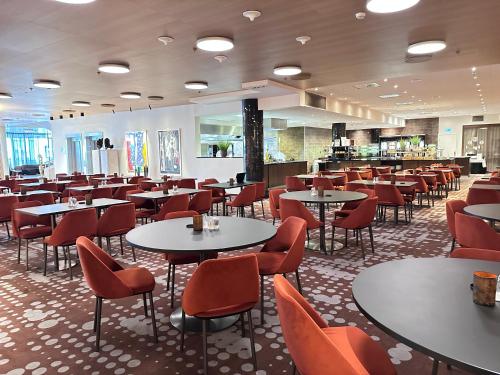 a restaurant with tables and chairs in a room at Scandic Parken in Ålesund