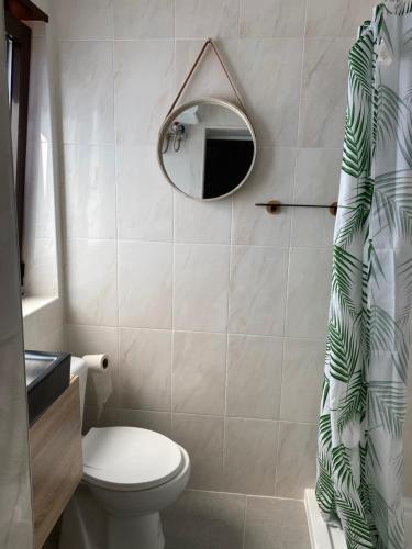 a bathroom with a toilet and a mirror at houses&halfhouses historic street in Caminha
