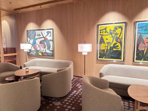 a lobby with chairs and tables and paintings on the wall at Scandic Parken in Ålesund