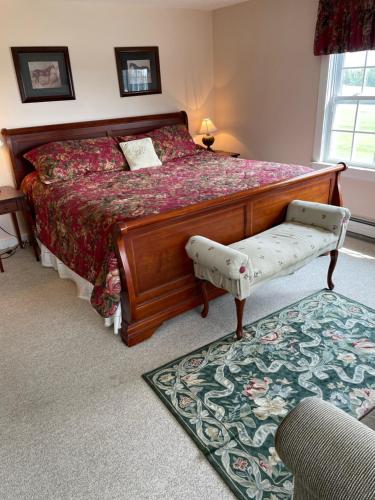 1 dormitorio con 1 cama grande con marco de madera en Cooper Hill Inn en West Dover