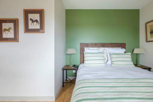 a bedroom with a bed and two tables with lamps at Le Domaine de Ravenoville - Pierres d'Histoire in Ravenoville