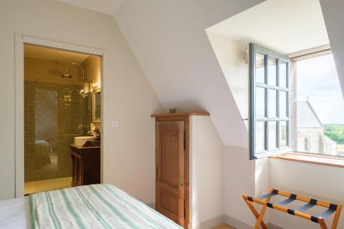 a bedroom with a bed and a window at Le Domaine de Ravenoville - Pierres d'Histoire in Ravenoville