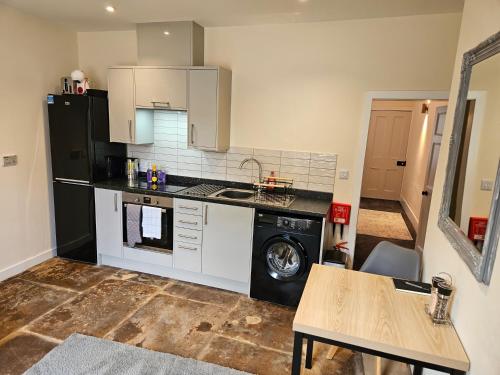 a kitchen with a black refrigerator and a table at Carlisle City Centre The Gavel in Carlisle