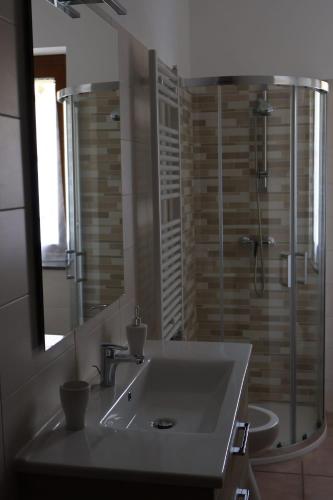 a bathroom with a sink and a shower and a mirror at B&b Mamì in Potenza