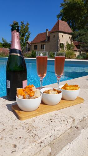 a table with bowls of food and glasses of wine at Ferme des Petites Oreilles 4 étoiles in Montignac