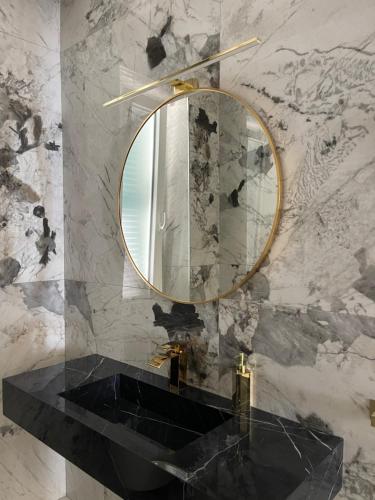 a bathroom with a gold mirror and a black sink at Maison 31 -Luxury Apartments in Santa Marinella