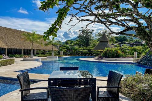 a table and chairs next to a swimming pool at Casa Tranquila - Ciudad del Mar 90 in Jacó