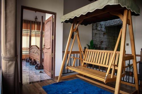 a room with two wooden benches and a fireplace at Boscage Homestay in Kandy