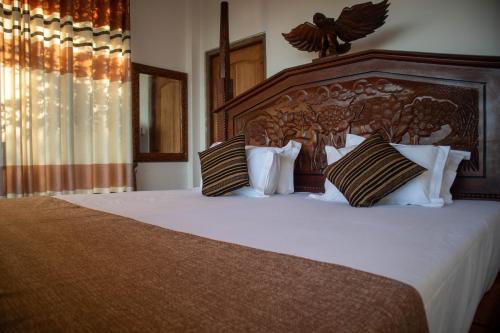 a bedroom with a large bed with white sheets and pillows at Boscage Homestay in Kandy