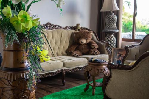 a teddy bear sitting on a couch in a living room at Boscage Homestay in Kandy