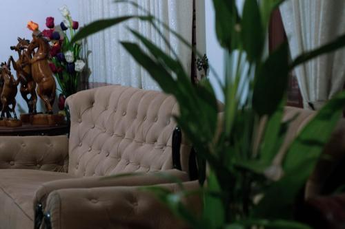 a living room with a couch and flowers at Boscage Homestay in Kandy
