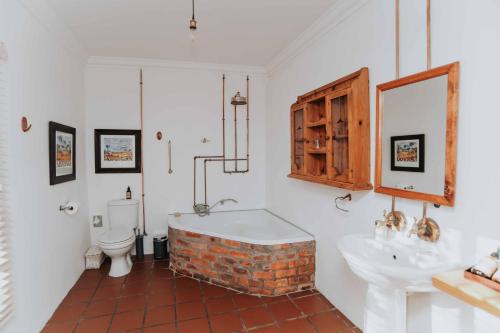 a bathroom with a tub and a toilet and a sink at Upington African Vineyard Boutique Hotel & SPA in Kanoneiland