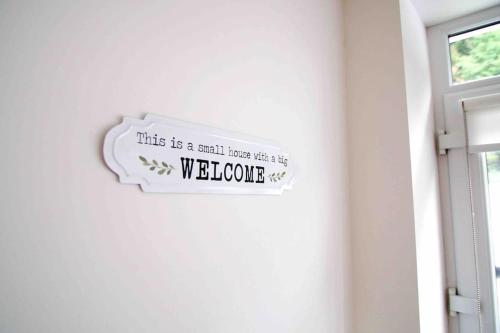 a sign that says this is a small house with a welcome at Newly refurbished flat, 1 min from Galgorm resort in Cullybackey