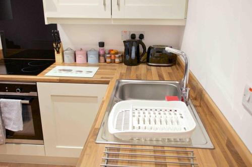 a kitchen counter with a sink in a kitchen at Newly refurbished flat, 1 min from Galgorm resort in Cullybackey