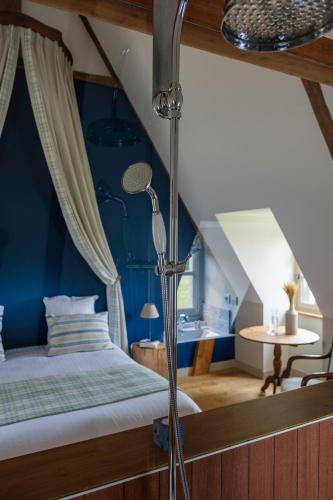 a bedroom with a bed with a blue wall at Le Domaine de Ravenoville - Pierres d'Histoire in Ravenoville