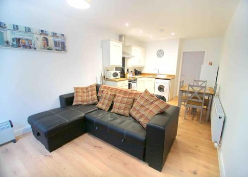 a living room with a couch and a kitchen at Newly refurbished flat, 1 min from Galgorm resort in Cullybackey