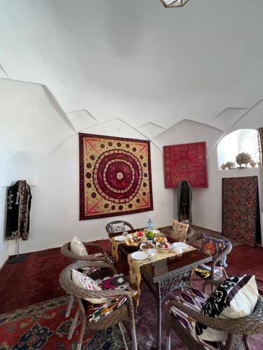 a living room with a table and chairs at Art Suzani in Bukhara