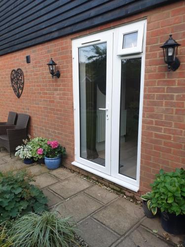 a white door on the side of a brick house at Fly By in Duxford