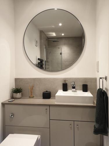 a bathroom with a sink and a mirror on the wall at Fly By in Duxford