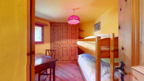 シルヴァプラーナにあるChampagna 5の二段ベッドとテーブルが備わる小さな客室です。