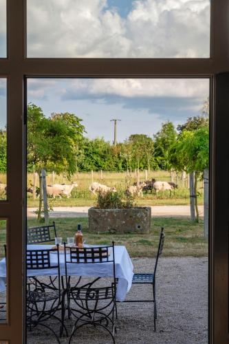 a view of a table and chairs from a window at Le Domaine de Ravenoville - Pierres d'Histoire in Ravenoville