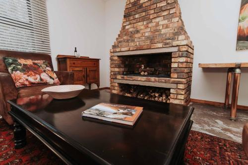 a living room with a couch and a fireplace at Upington African Vineyard Boutique Hotel & SPA in Kanoneiland