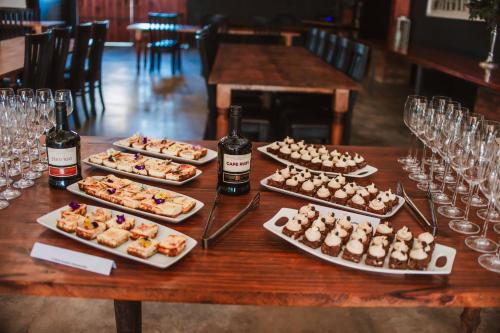 a table with plates of food and bottles of wine at Upington African Vineyard Boutique Hotel & SPA in Kanoneiland