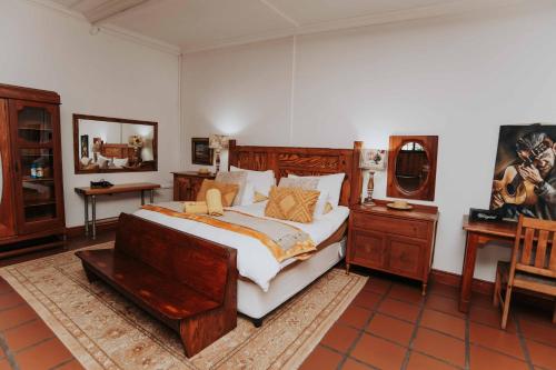 a bedroom with a large bed and wooden furniture at Upington African Vineyard Boutique Hotel & SPA in Kanoneiland