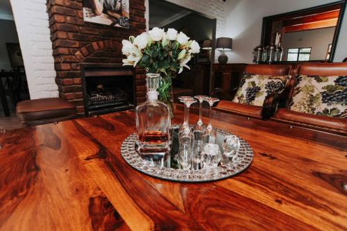 a table with two glasses and a vase on it at Upington African Vineyard Boutique Hotel & SPA in Kanoneiland