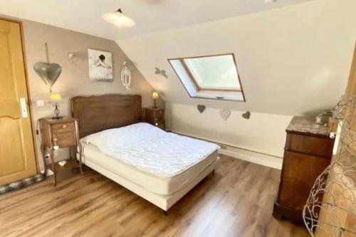 a bedroom with a bed and a window and wooden floors at Les Anatidés, Quend in Quend