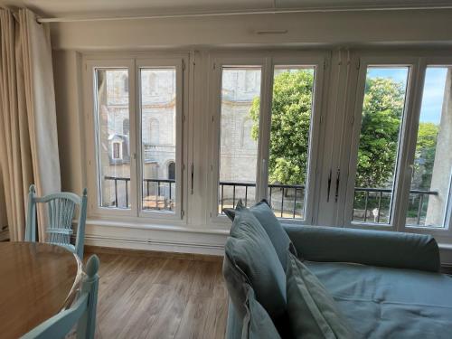 un soggiorno con divano e ampie finestre di Le plage de Notre-Dame - Appartement au coeur de la vieille ville a Boulogne-sur-Mer