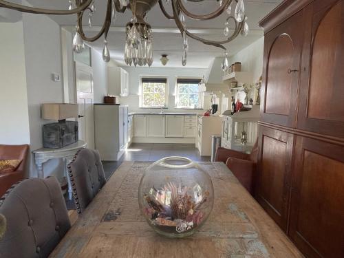 a dining room with a table with a fish bowl on it at Luxe vakantiewoning op de Goudsberg in Lunteren