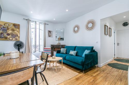 un salon avec un canapé bleu et une table dans l'établissement MBA Splendide Appart - Montreuil 4 - Proche Vincennes, à Montreuil