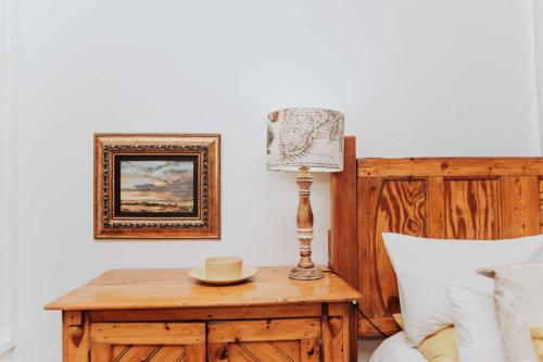 a lamp on a wooden table next to a bed at Upington African Vineyard Boutique Hotel & SPA in Kanoneiland
