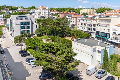 an aerial view of a city with cars parked in a parking lot at Palácio Estoril Hotel, Golf & Wellness in Estoril