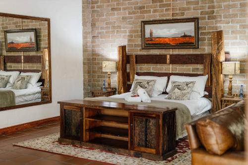 a bedroom with a bed and a table and mirrors at Upington African Vineyard Boutique Hotel & SPA in Kanoneiland